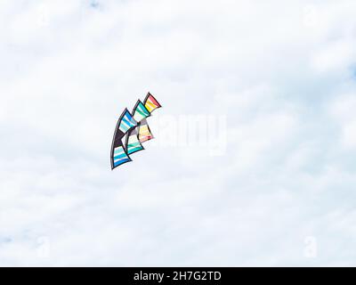 Stack of three quad line stunt kites against white clouds. Stock Photo