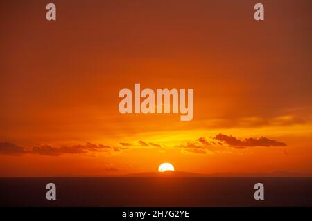 The sun setting over the sea from South Stack Lighthouse,Holy Island, Anglesey, Wales Stock Photo