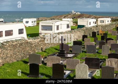 Caravan site just over the wall from the graveyard at St Eilian's Church, Llaneilian, Anglesey, wales Stock Photo