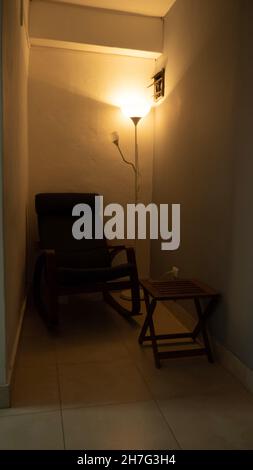 Lamp lit in the living room of the house illuminating the wall Stock Photo