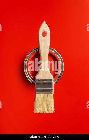 Clean paint brush and can of color on red background. Stock Photo