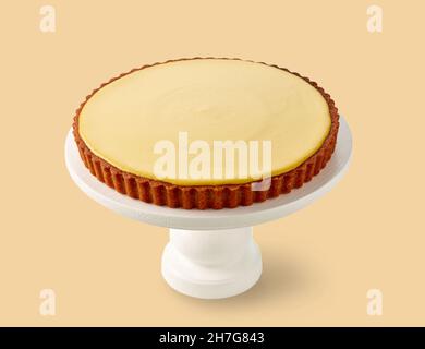 fresh mango vegan cake on wooden stand isolated on yellow background Stock Photo
