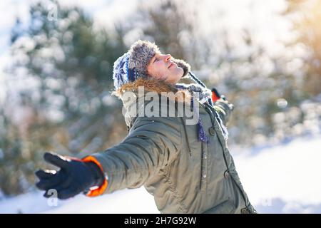 Young handsome man having fun in woods in winter scenery Stock Photo
