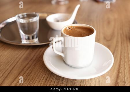 Traditional Turkish coffee with cold water and Turkish delight in cafe. Selective focus - Image Stock Photo