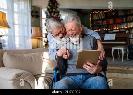 Senior couple having fun and laughing while using their tablet pc computer. Stock Photo