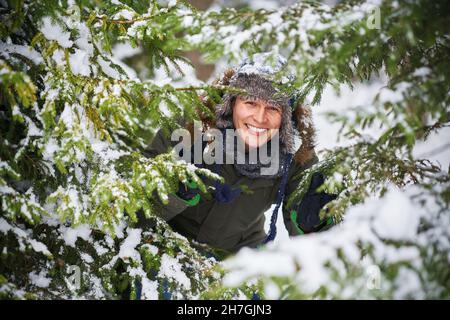 Young handsome man having fun in woods in winter scenery Stock Photo