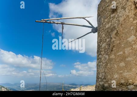 Panoramic view over the Lasithi Plateau in Crete, Greece with on top of the mountains a side view of a typical stone white-sailed windmill Stock Photo