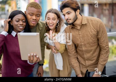 Multiracial students watch some on digital tablet Stock Photo
