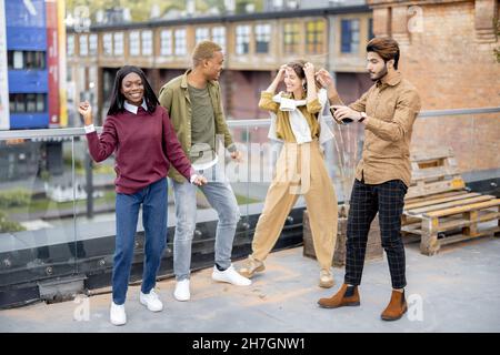 Students celebrate on balcony at university campus Stock Photo