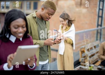 Students use digital devices at university campus Stock Photo