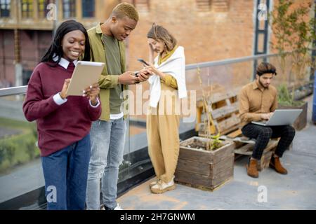 Students use digital devices at university campus Stock Photo