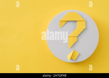 Colorful yellow origami question mark on a white paper circle over a matching yellow background with copy space for a design template Stock Photo