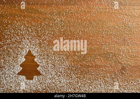 Christmas background with fir-shaped drawn with icing sugar powder on wooden base. Top view. Horizontal composition. Stock Photo
