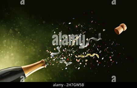 Festive concept with freshly opened bottle of sparkling wine with confetti and ribbons coming out on green isolated background Stock Photo