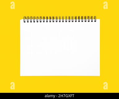 Blank spiral bound notebook on a yellow background Stock Photo