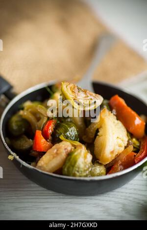 fried brussels sprouts with cauliflower and other vegetables in a frying pan Stock Photo