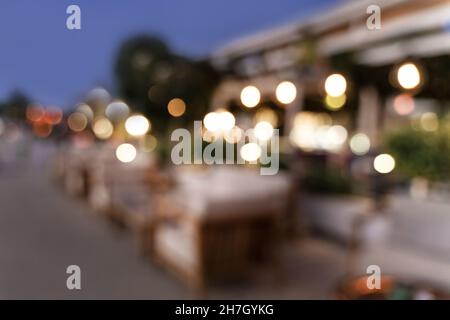 Abstract blured defocused image of European cosy cafe at dusk with beautiful bokeh lights. Great backdrop for your design. Travel concept. Copy space. Stock Photo