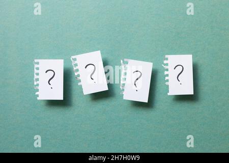 Question mark on ripped note on green background. Thinking, solution, business, idea concept Stock Photo