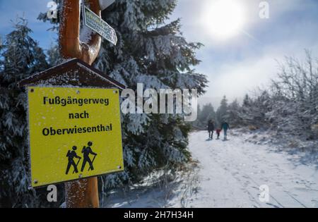 Oberwiesenthal, Germany. 23rd Nov, 2021. A family hikes through the snow to the summit of the Fichtelberg. The meteorologists predict further frosty temperatures for the coming days. (Aerial photo with drone) Credit: Jan Woitas/dpa-Zentralbild/dpa/Alamy Live News Stock Photo