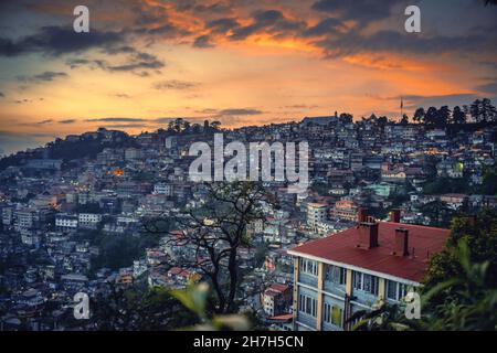 Beautiful sunset over a mountain slope engulfed with buildings in Shimla, North India Stock Photo