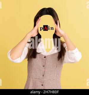Contemporary artwork. Conceptual portrait of faceless woman with word pain instead face. Human emotions, psychology, mental health concept. Stock Photo