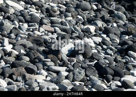 Close up of black lava rocks and pebbles on a beach in Iceland Stock Photo