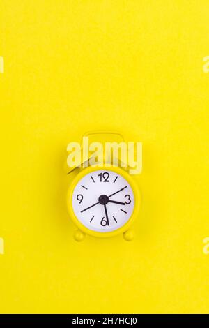 A yellow alarm clock on a yellow background is a copy device. An article about time. An article about an alarm clock. Stock Photo