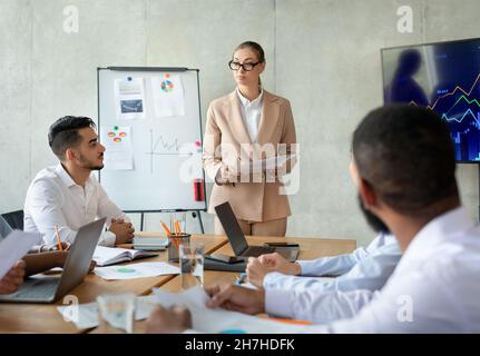 Young Confident Businesswoman Having Corporate Meeting With Colleagues In Boardroom Stock Photo