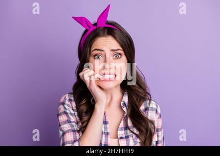 Photo portrait of scared woman biting nails isolated on vivid purple colored background Stock Photo