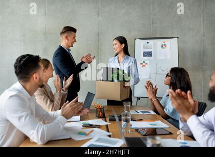 Group Of Business People Applauding, Greeting Asian Female Employee In Their Team Stock Photo
