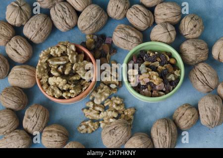 Walnuts and dried fruits in two bowls, shelled and shelled walnuts and granola Stock Photo