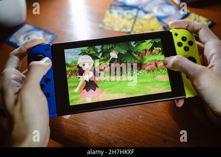 Bangkok, Thailand - November 23, 2021 : Gamer playing Pokémon Brilliant Diamond and Shining Pearl game on Nintendo Switch. Stock Photo