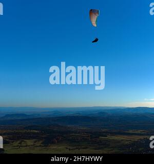 Paraglider in flight over the volcanoes of Auvergne. Puy de Dome Stock Photo