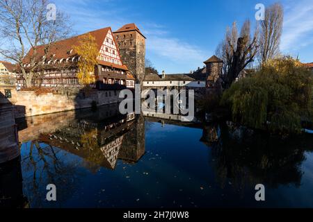 Nuremberg, Germany. 23rd Nov, 2021. The Henkerhaus Museum (r) and the Weinstadel (l) are reflected in the Pegnitz in the old town. Credit: Daniel Karmann/dpa/Alamy Live News Stock Photo