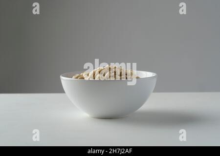 Loop cereals in a white bowl on a white table with grey background Stock Photo