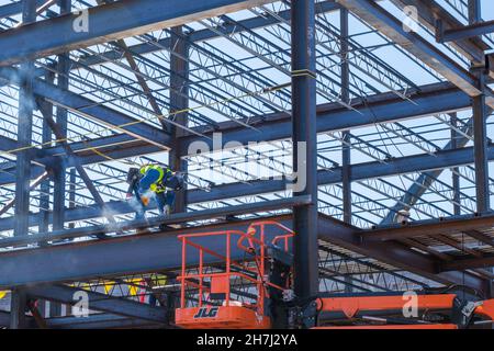NEW ORLEANS, LA, USA - NOVEMBER 16, 2021: Welder working on steel beams of building and generating smoke Stock Photo