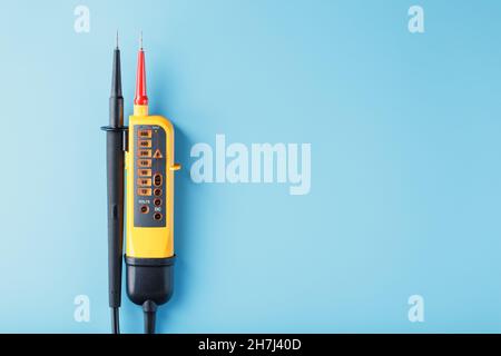 Two-pole voltage indicator close-up on a blue background. Testing and verification of electrical networks Stock Photo