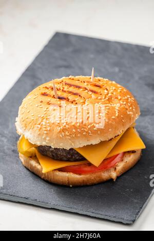 still life of cheeseburger on black plate Stock Photo
