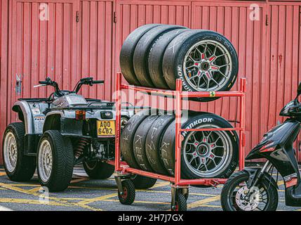 BARCELONA, SPAIN - Oct 25, 2021: Quad, scooter, and wheels in the boxes on the background of a red wall. Aprilia SR 125 Stock Photo