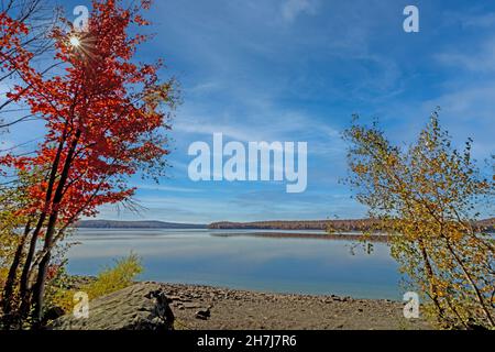 Lake Wallenpaupack in Poconos PA on a bright fall day lined with trees in vivid and beautiful foliage Stock Photo