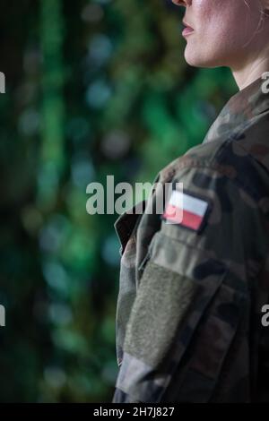 Arm of a Polish lady soldier with the national white and red flag of Poland. Close-up view. Stock Photo