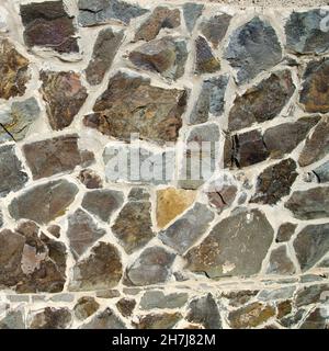 Stone wall made of different shaped stones. Realistic texture background Stock Photo