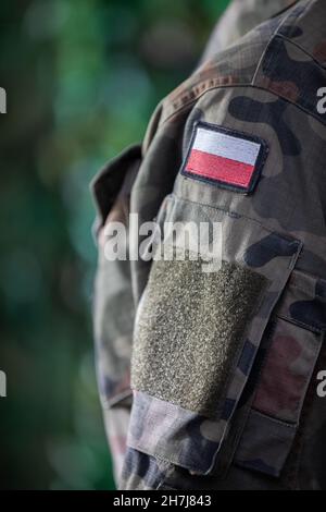 The arm of a Polish soldier with the national white and red flag. Close-up view. Stock Photo