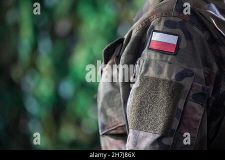 The arm of a Polish soldier with the national white and red flag. Close-up view. Stock Photo