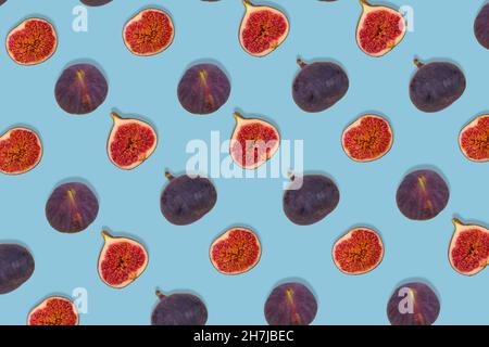 Pattern of fresh ripe whole and sliced figs on blue background. Creative food concept. Vegetarian diet idea. Flat lay Stock Photo