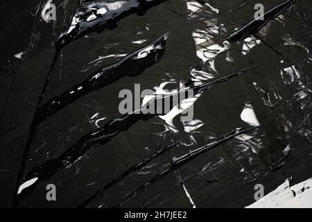Black-white background with smudges and splashes of paint. Dark colored putty texture top view. Wet paint on canvas. Abstract background with brush st Stock Photo
