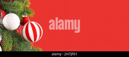 Christmas banner with striped red and white bauble on tree branch Stock Photo