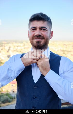 Man buttons his white shirt up Stock Photo