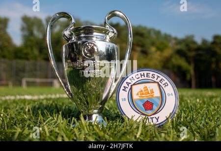 August 30, 2021 Manchester, UK. Manchester City F.C. football club emblem and the UEFA Champions League Cup on a green turf. Stock Photo