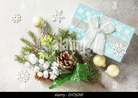 Christmas or New Year holidays composition layout. Fir tree snow branch, Christmas present and decoration on a stone tabletop. Flat lay. Stock Photo